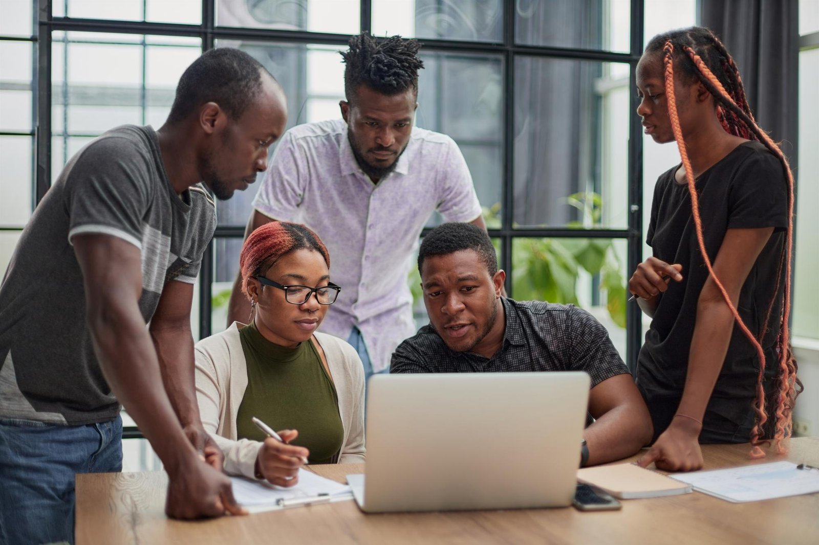 A team gathered around a laptop, planning a communications campaign